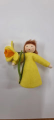 Handgemachte Filzpuppe in gelbem Kleid mit braunen Haaren und gelber Blume