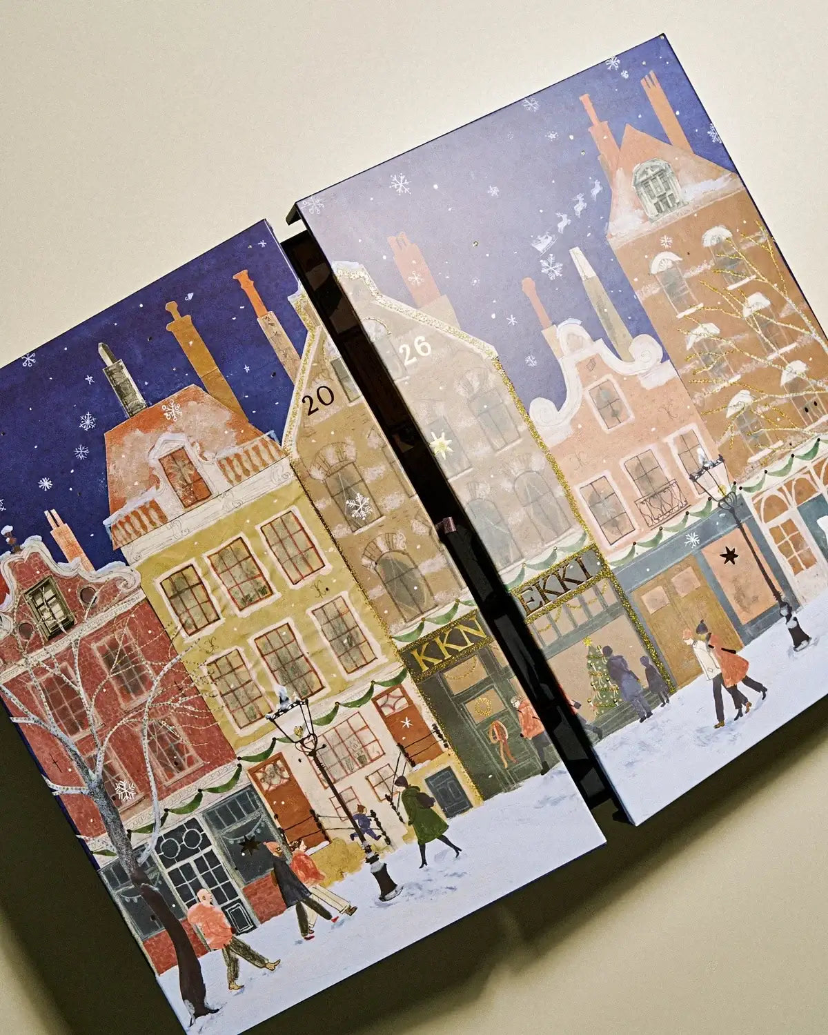 Illustrierter Adventskalender mit verschneiter Stadtansicht und weihnlichen Motiven