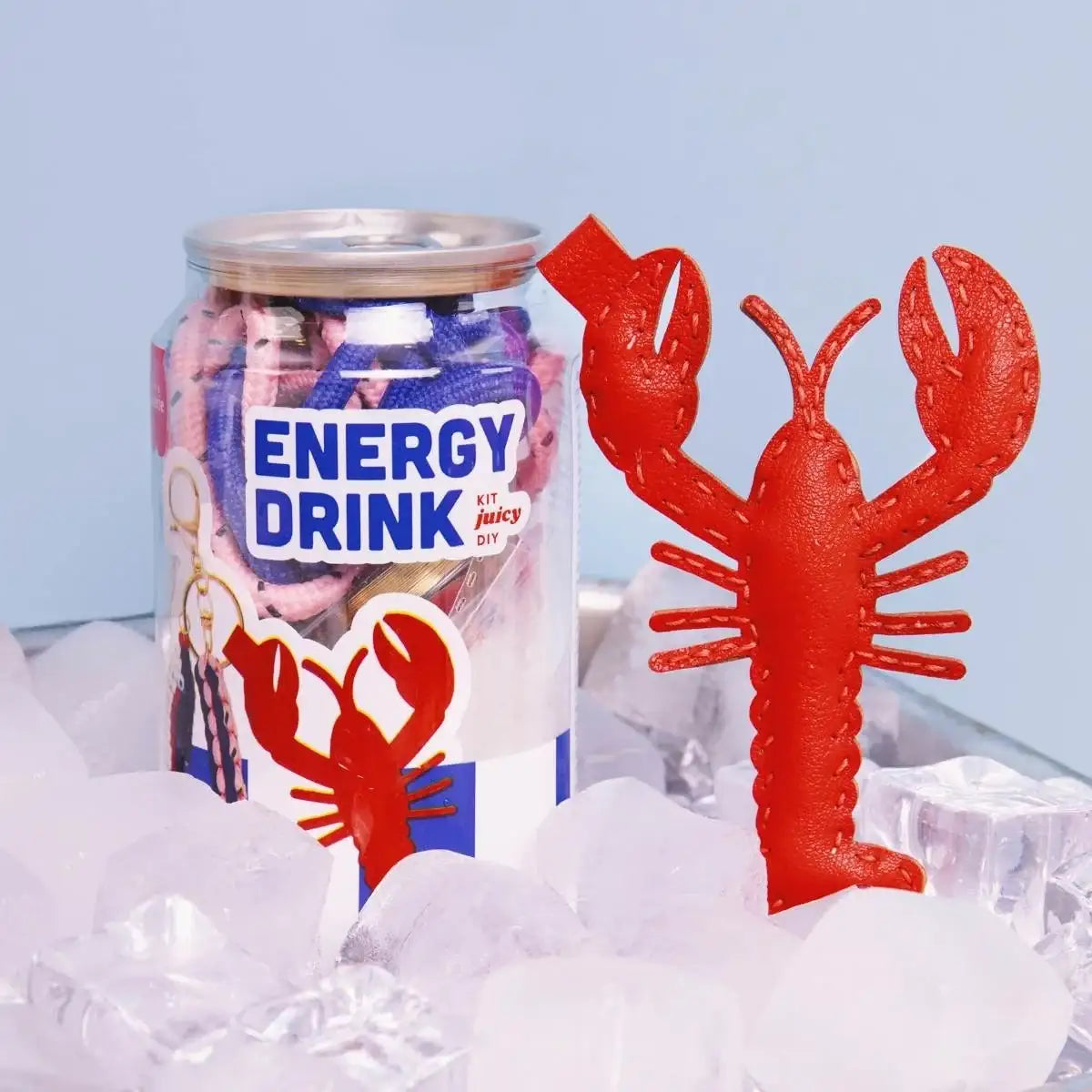 Roter Lederhummer neben DIY-Energy-Drink-Kit in Dose auf Eiswürfeln, kreatives Bastelset für Kinder