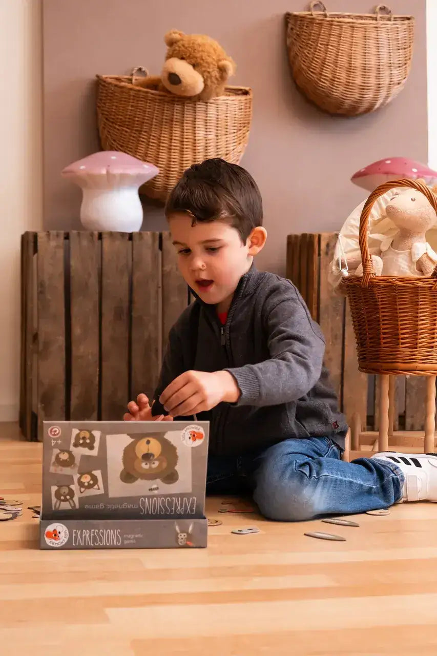 Kind spielt mit magnetischem Ausdrucksspiel, umgeben von Körben und Spielzeug in einem nachhaltigen Spielzeugladen.