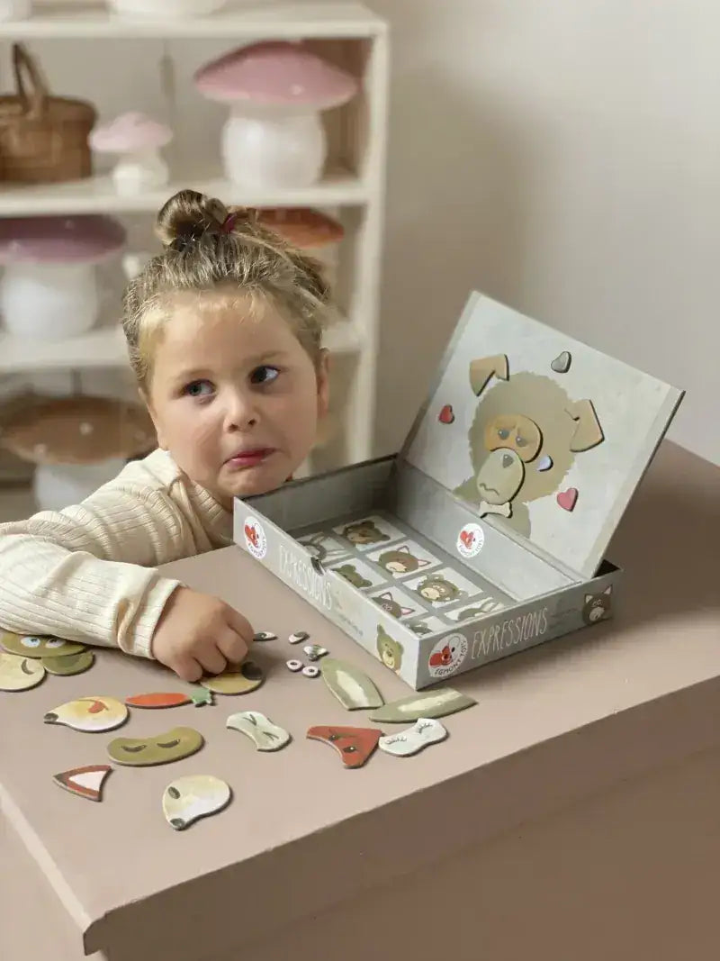 Kind spielt mit Holz-Gesichtsausdruck-Puzzle, nachhaltiges Lernspielzeug für Emotionen erkennen