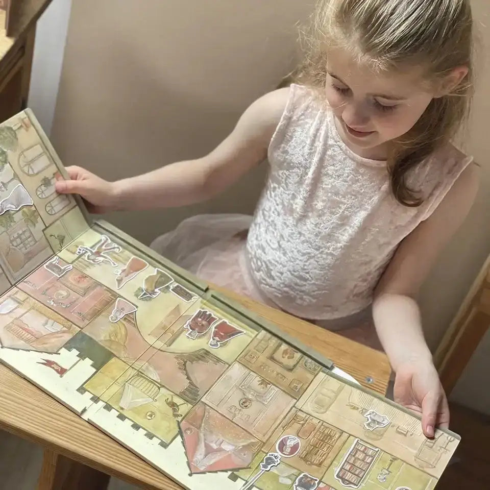 Mädchen spielt mit Egmont Magnetspiel Prinzessin auf Holztisch, wandert Figuren auf illustriertem Schlossplan